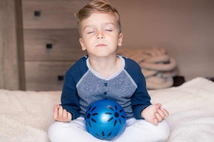 Peaceful boy meditating in the morning.