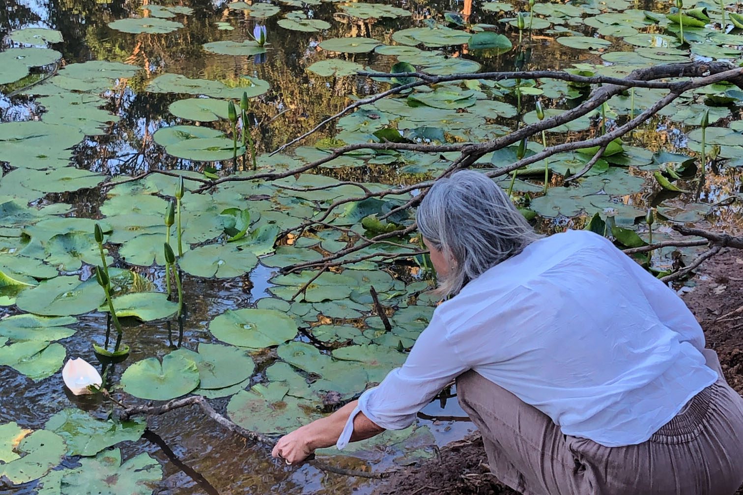 Mt Burrell Private Wellness Retreat 13 Woman putting paper boat on pond | Wellness Retreat Image Haven Yoga & Meditation