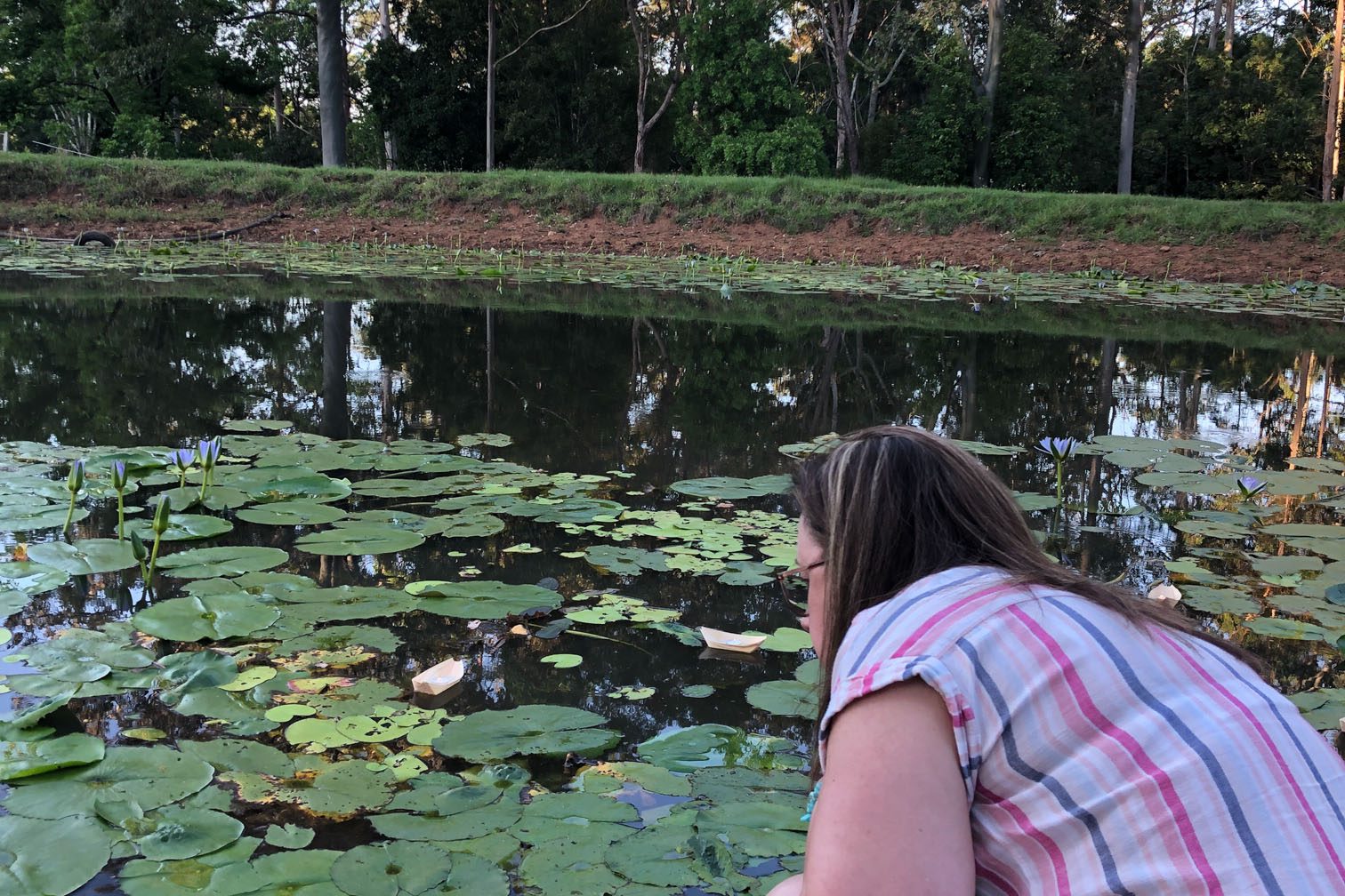 Mt Burrell Private Wellness Retreat 14 Woman putting paper boat on pond | Wellness Retreat Image Haven Yoga & Meditation
