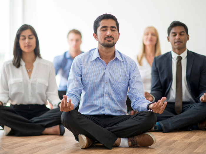 Yoga for Business Company employees meditating in a room - Haven Yoga and Meditation blog image