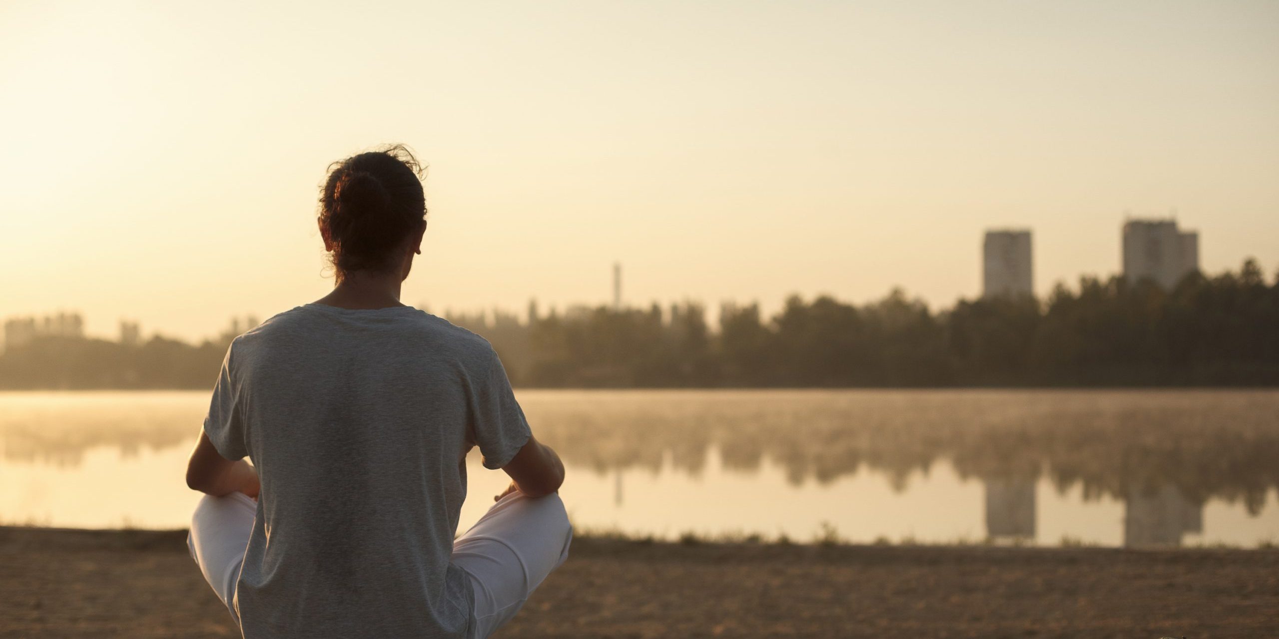 brisbane meditation Woman meditating beside the lake - Haven Yoga and Meditation blog image