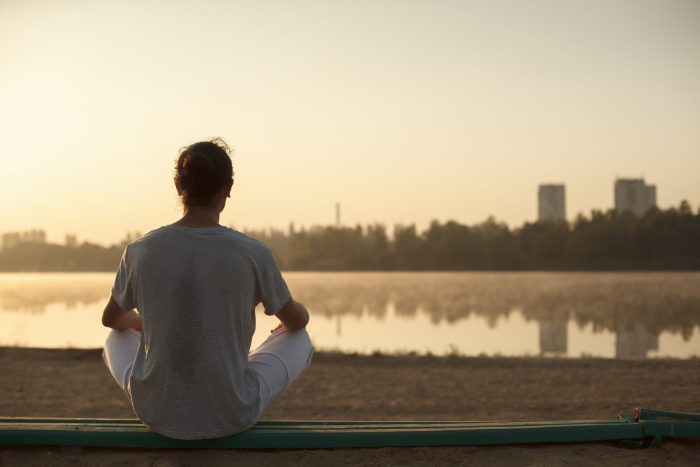 brisbane meditation Woman meditating beside the lake - Haven Yoga and Meditation blog image