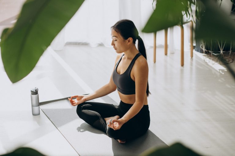 Woman practicing yoga on mat at home Kundalini Yoga